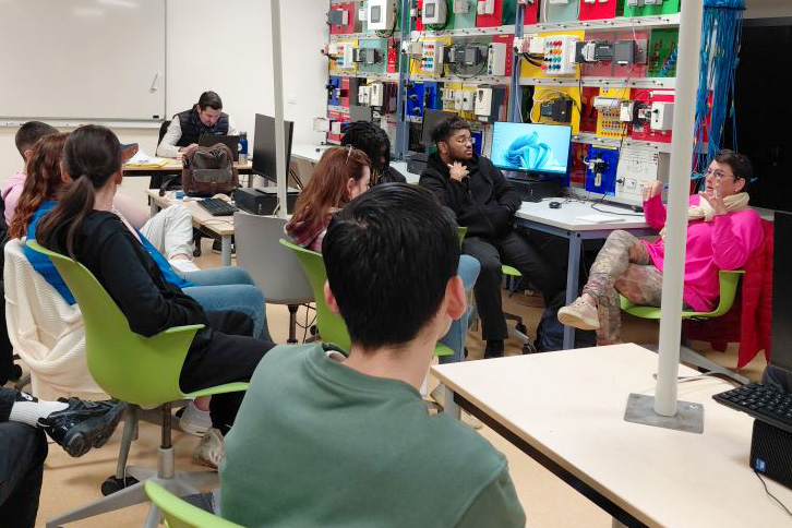 Les bénéficiaires du programme Skola sont dans une salle en train d'écouter une collaboratrice parler