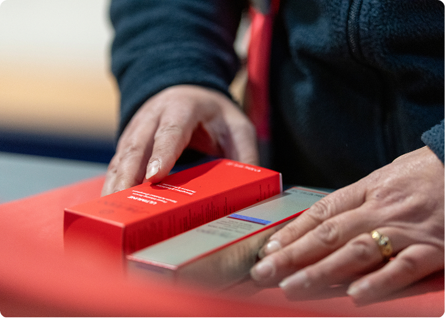 Operator handling luxury beauty packaging during a co-packing process