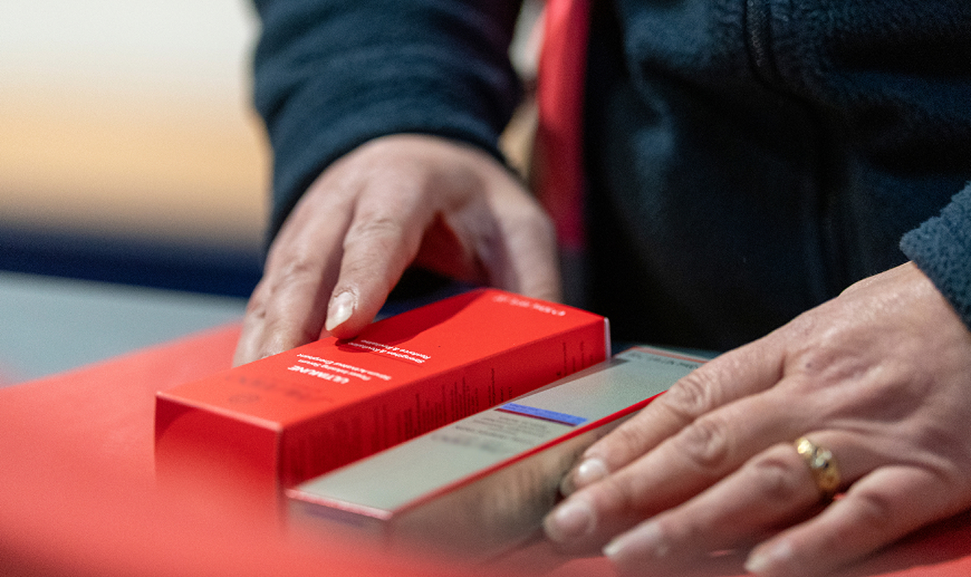 Operator handling luxury beauty packaging during a co-packing process