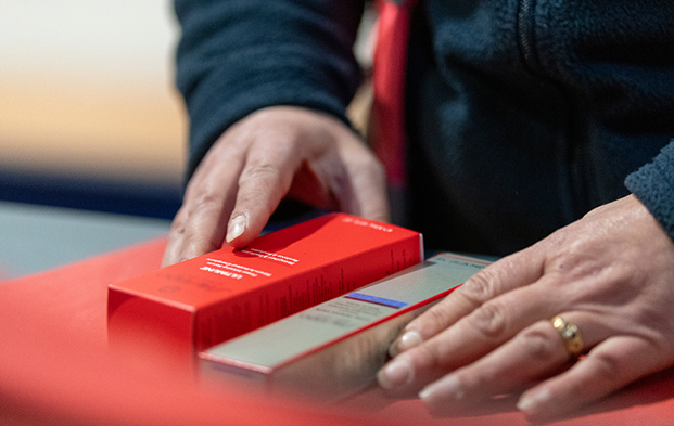 Operator handling luxury beauty packaging during a co-packing process