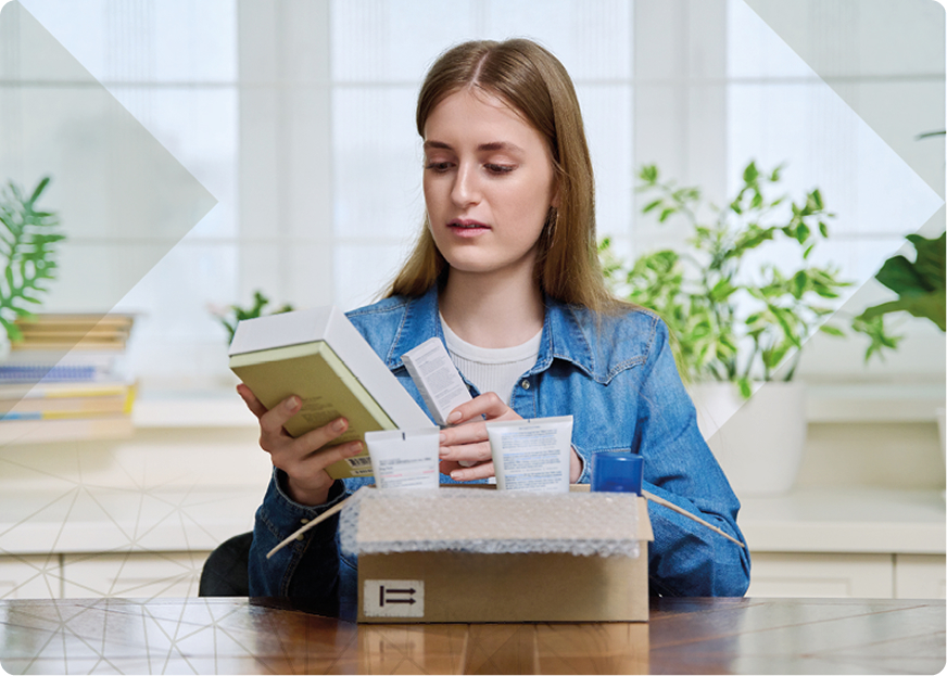 Woman unpacking beauty products from a cardboard box, illustrating the role of the luxury supply chain in customer experience.