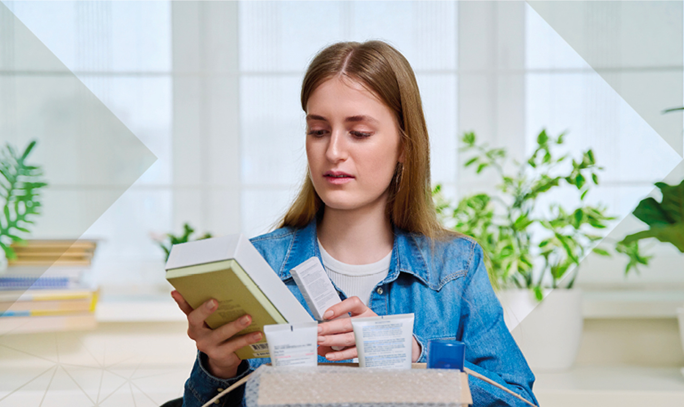 Woman unpacking beauty products from a cardboard box, illustrating the role of the luxury supply chain in customer experience.