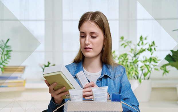 Woman unpacking beauty products from a cardboard box, illustrating the role of the luxury supply chain in customer experience.